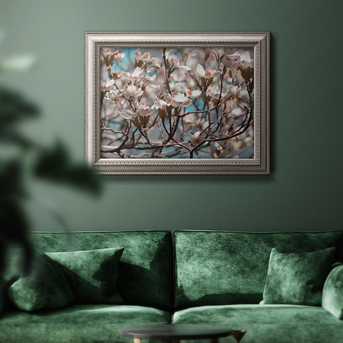 Contemporary dogwood blossom floral photography in an ornate vintage silver frame displayed in a dark-toned interior setting.