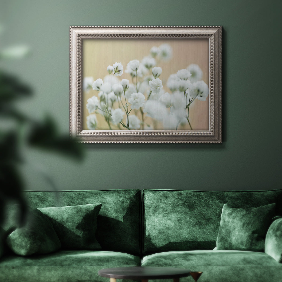 Delicate baby’s breath floral photograph in an ornate vintage silver frame displayed in a dark-toned interior setting.