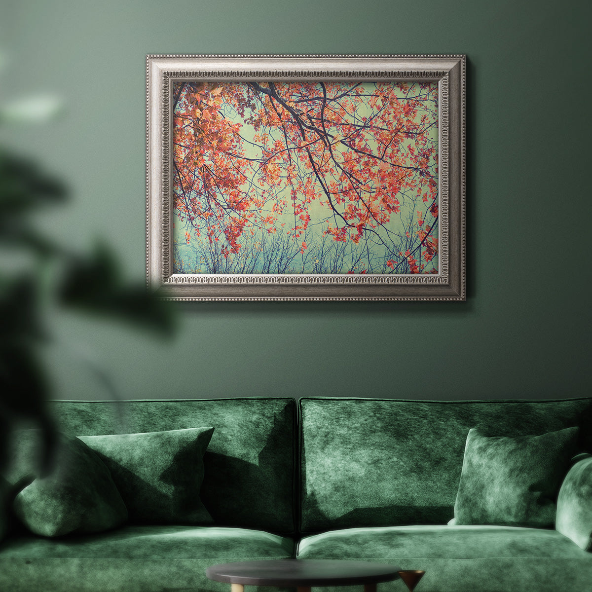 Eclectic fall floral landscape artwork in an ornate vintage silver frame displayed in a dark-toned interior setting.