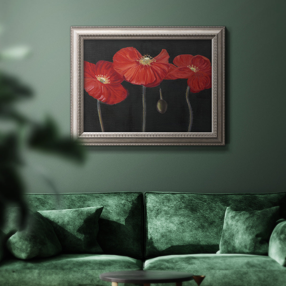 Modern red poppy floral artwork in an ornate vintage silver frame displayed in a dark-toned interior setting.