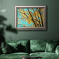 Bright autumn leaves against a blue sky in an ornate vintage silver frame displayed in a dark-toned interior setting.
