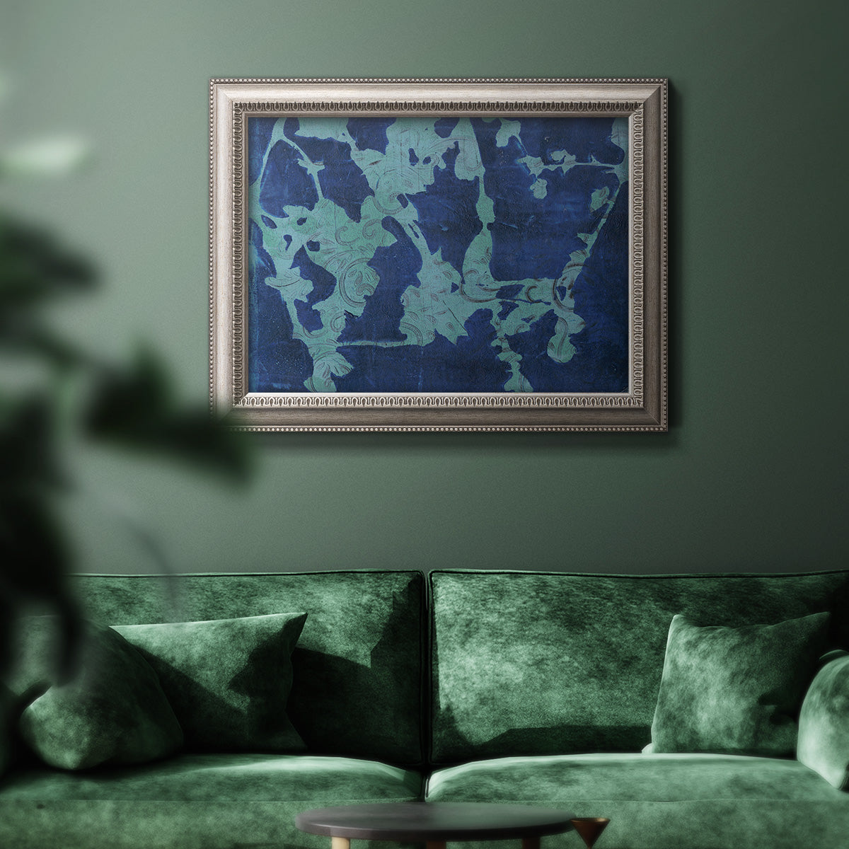 Blue abstract botanical in an ornate vintage silver frame displayed in a dark-toned interior setting.