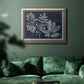 Antique botanical foliage artwork on navy background in an ornate vintage silver frame displayed in a dark-toned interior setting.
