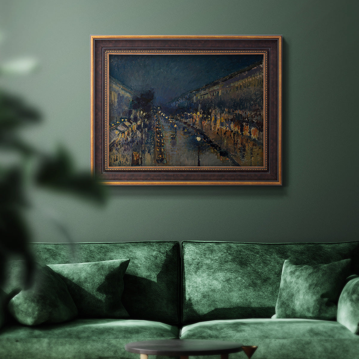 Impressionist nighttime Paris street scene by Camille Pissarro in an ornate bronzed mahogany wood frame displayed in a dark-toned interior setting.
