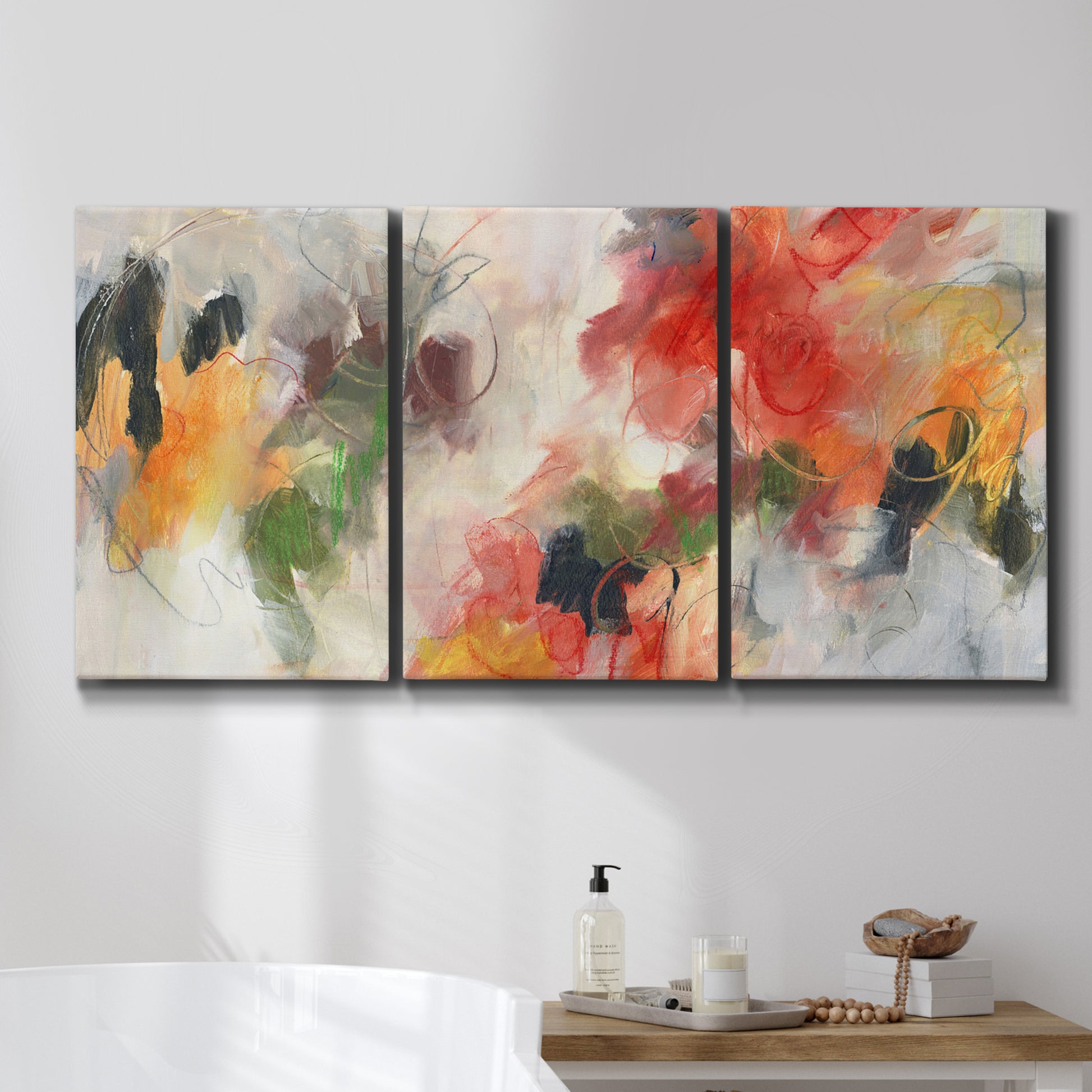 Three-panel canvas wall art featuring abstract floral color composition, displayed in a bathroom above a bathtub.