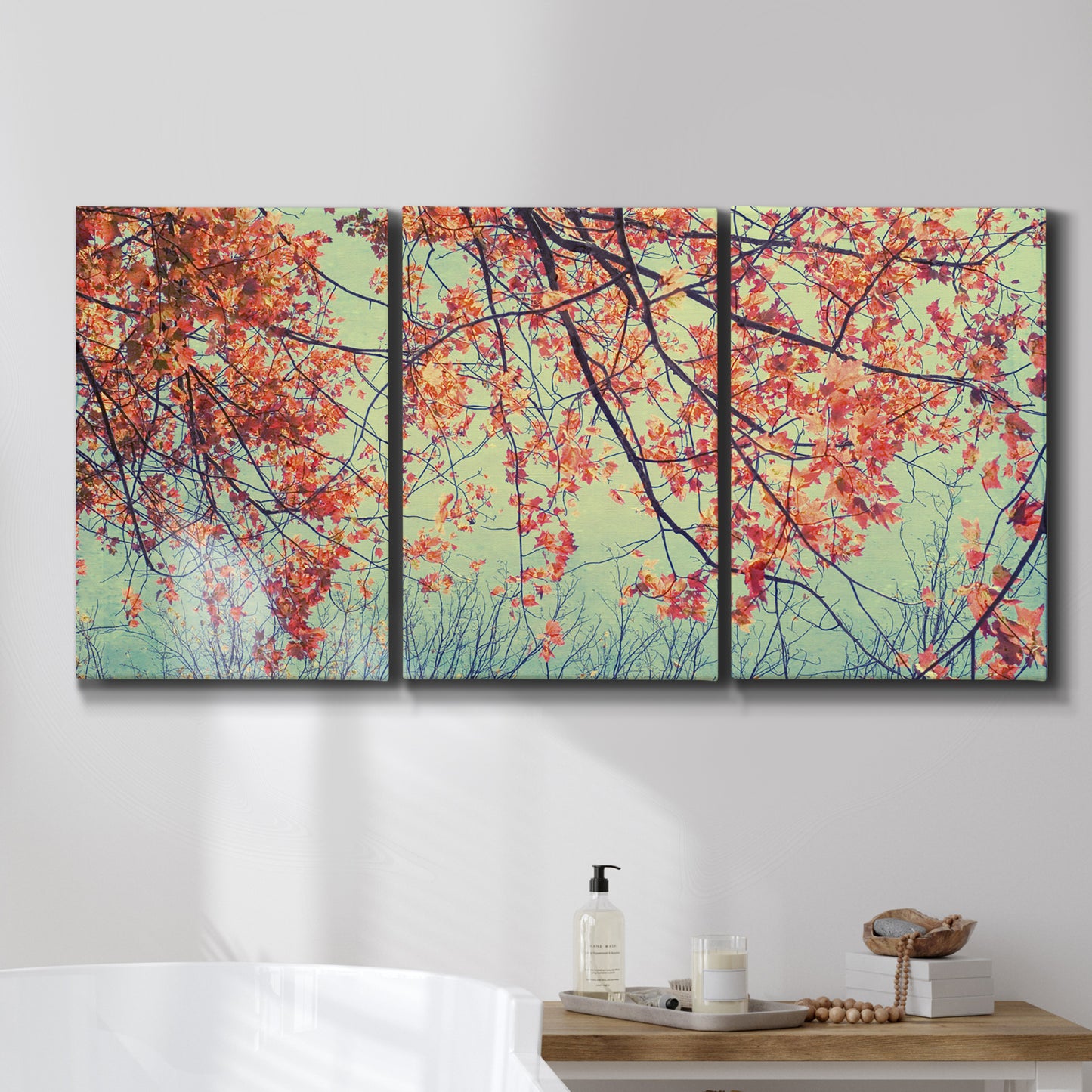 Three-panel canvas wall art featuring autumn foliage landscape photograph, displayed in a bathroom above a bathtub.