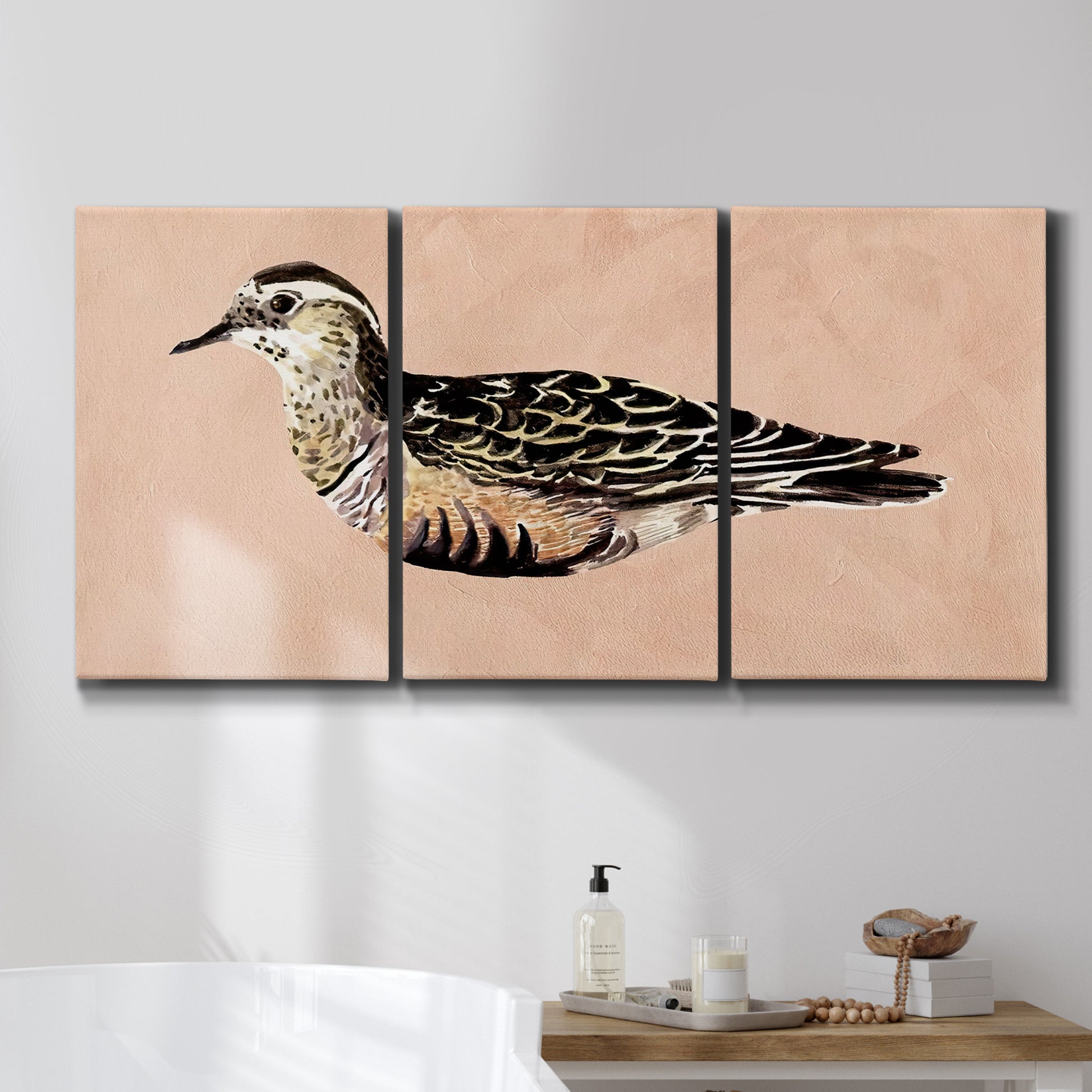 Three-panel canvas wall art featuring coastal bird illustration, displayed in a bathroom above a bathtub.