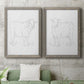 Set of two gray barnwood framed canvas prints depicting a coordinated art pair of simple contour drawings of standing cows rendered as minimalist livestock sketches above a sofa in a modern living room.