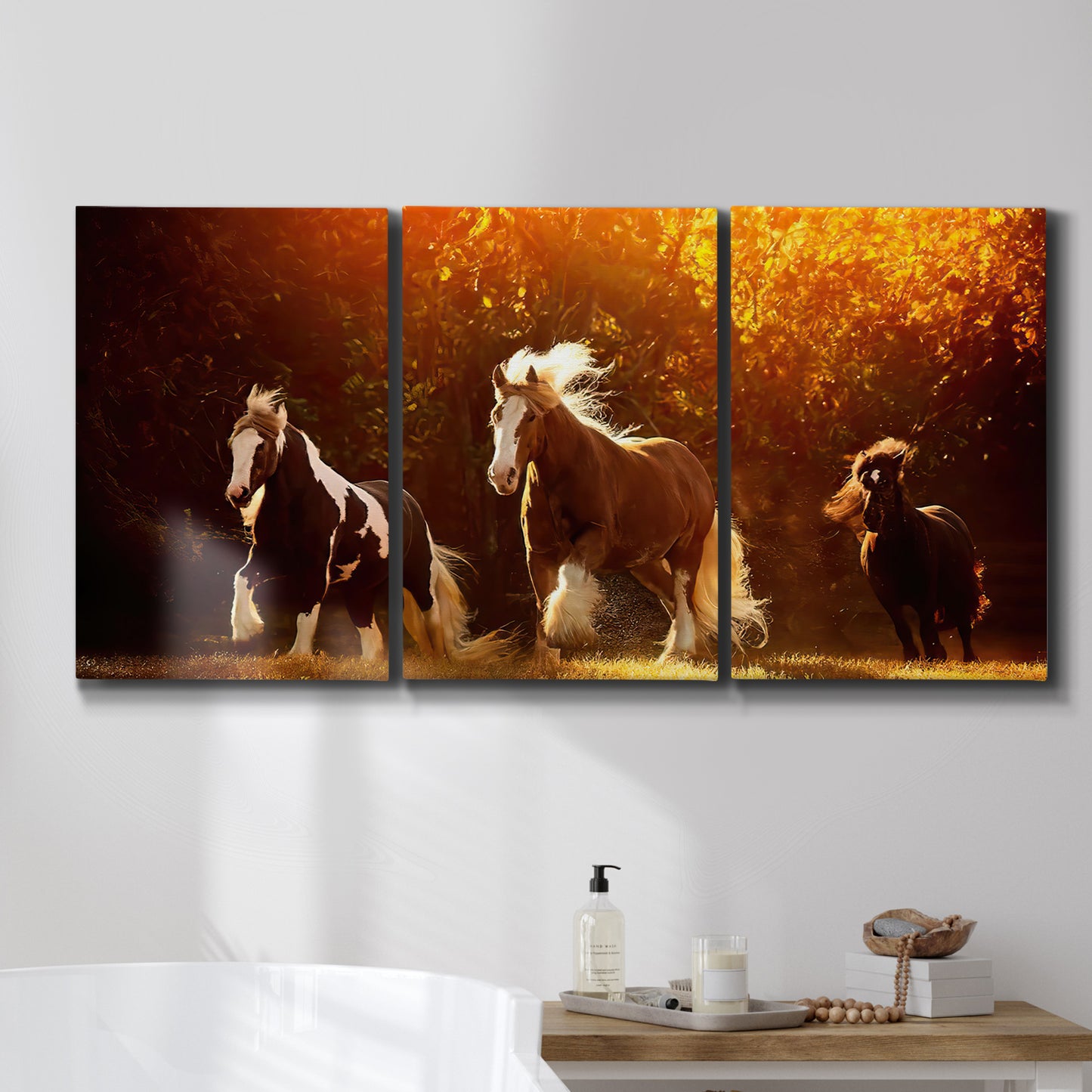Three-panel canvas wall art featuring running horses across open field, displayed in a bathroom above a bathtub.