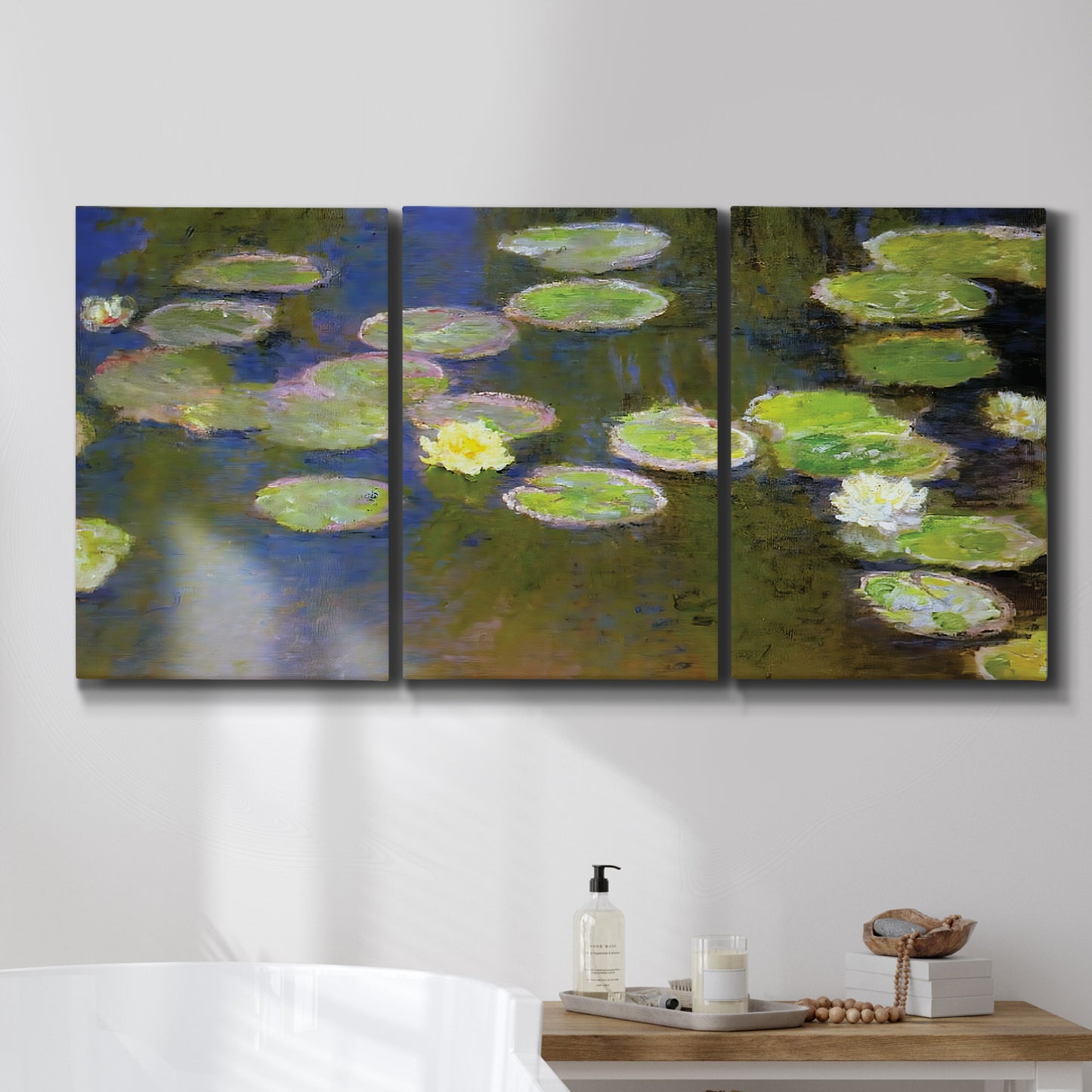Three-panel canvas wall art featuring yellow and white water lilies, displayed in a bathroom above a bathtub.