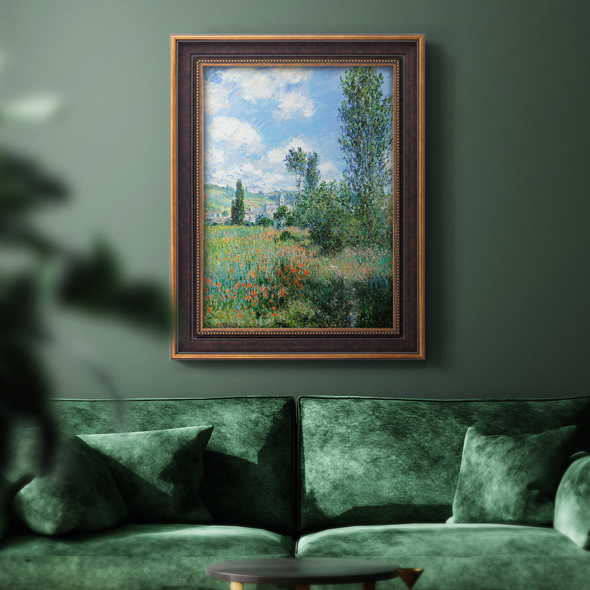 Impressionist pastoral landscape with poppy fields by Claude Monet in an ornate bronzed mahogany wood frame displayed in a dark-toned interior setting.