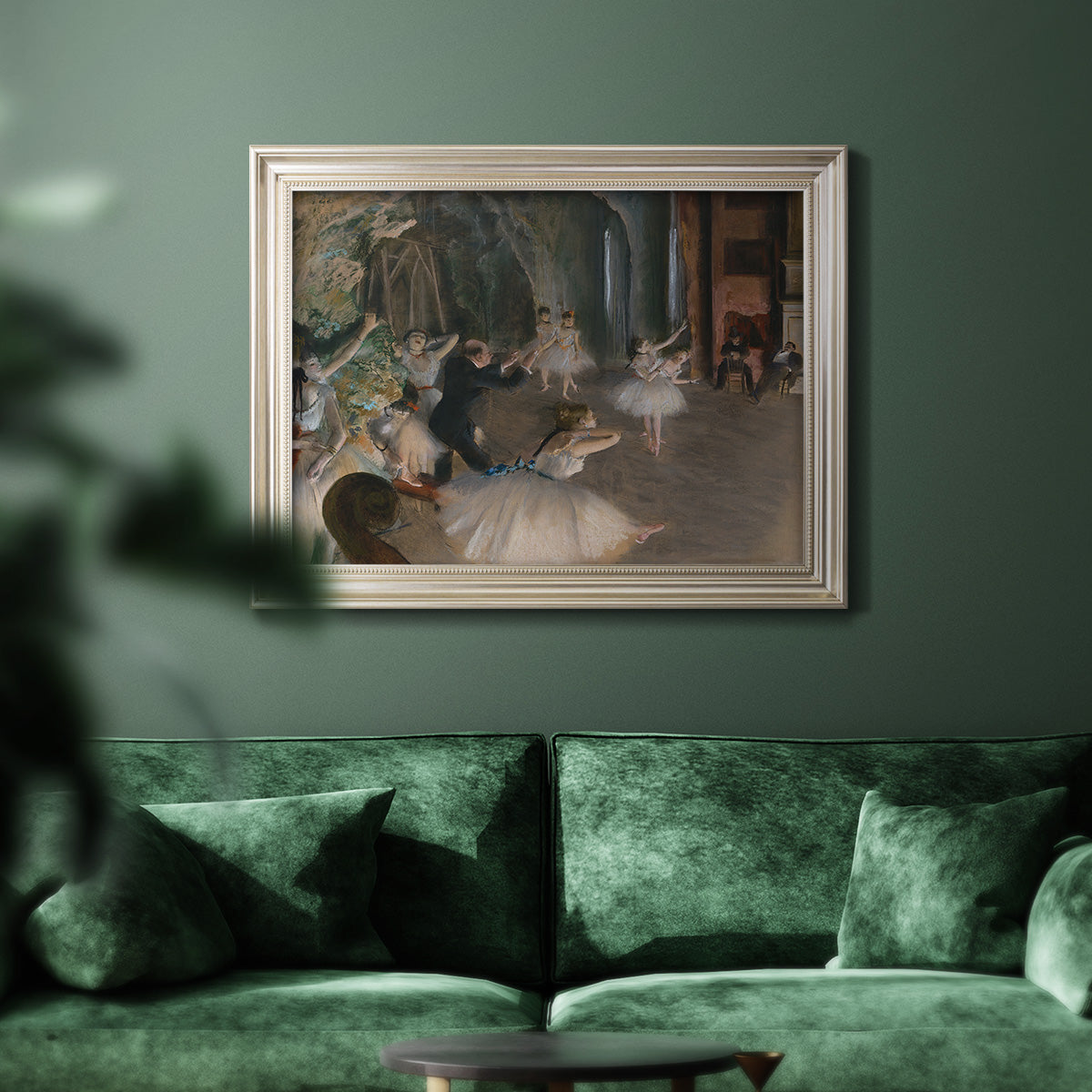 Impressionist backstage ballet scene by Edgar Degas in an ornate champagne frame displayed in a dark-toned interior setting.