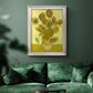 Impressionist sunflower still life painting by Vincent van Gogh in an ornate champagne frame displayed in a dark-toned interior setting.