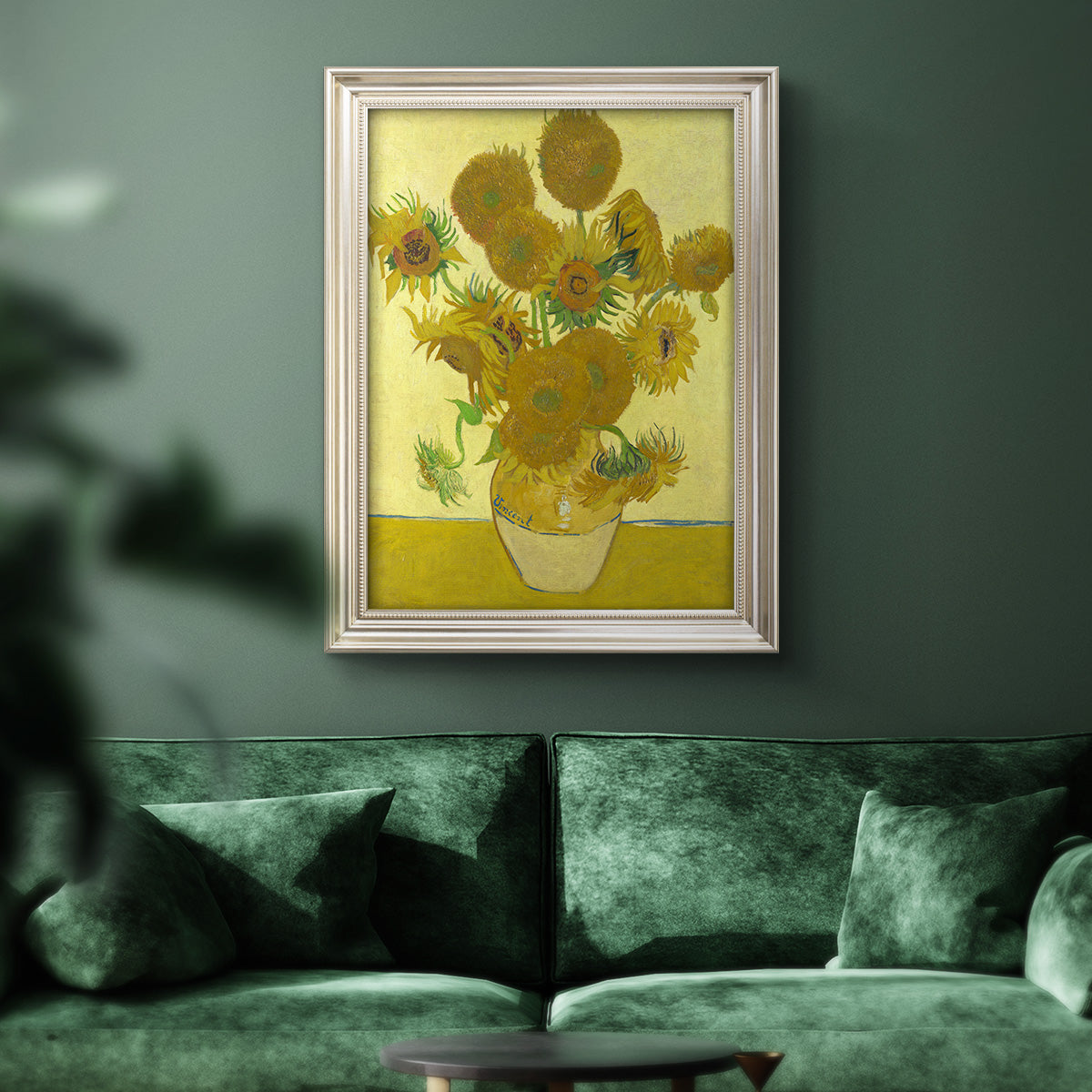 Impressionist sunflower still life painting by Vincent van Gogh in an ornate champagne frame displayed in a dark-toned interior setting.