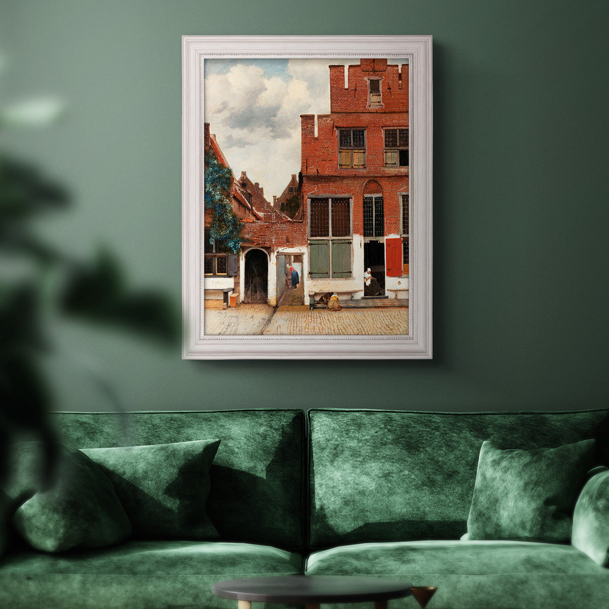 Realist city street scene by Johannes Vermeer in an ornate weathered white frame displayed in a dark-toned interior setting.