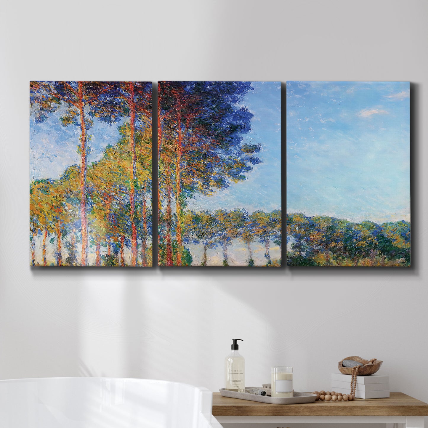 Three-panel canvas wall art featuring autumn poplar trees along river, displayed in a bathroom above a bathtub.