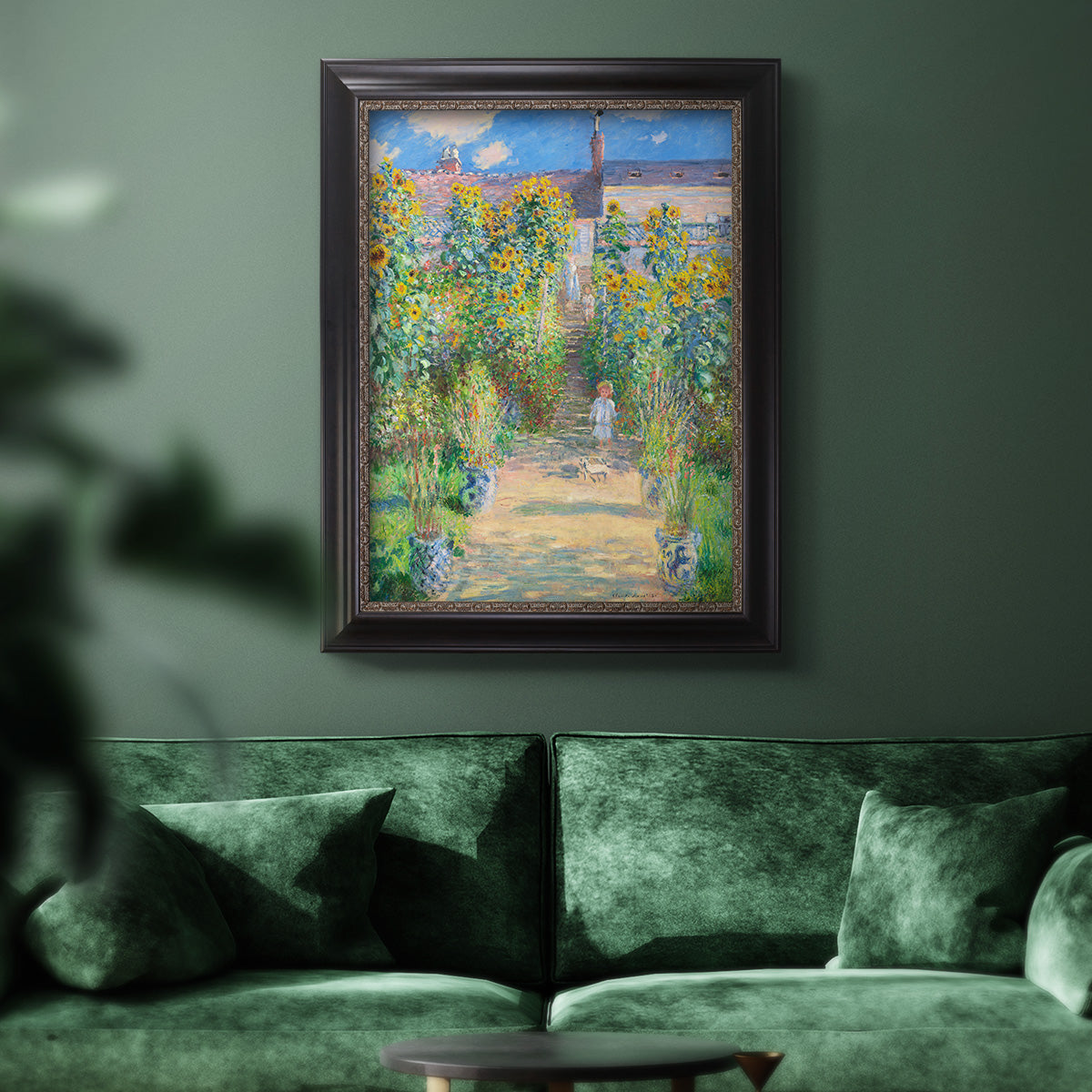 Impressionist garden landscape painting by Claude Monet in an ornate black frame with gilded inner detail displayed in a dark-toned interior setting.