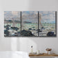 Three-panel canvas wall art featuring rough seas along rocky coast, displayed in a bathroom above a bathtub.