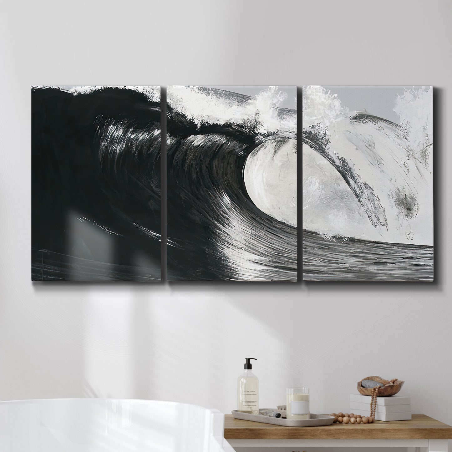 Three-panel canvas wall art featuring black and white crashing ocean waves, displayed in a bathroom above a bathtub.