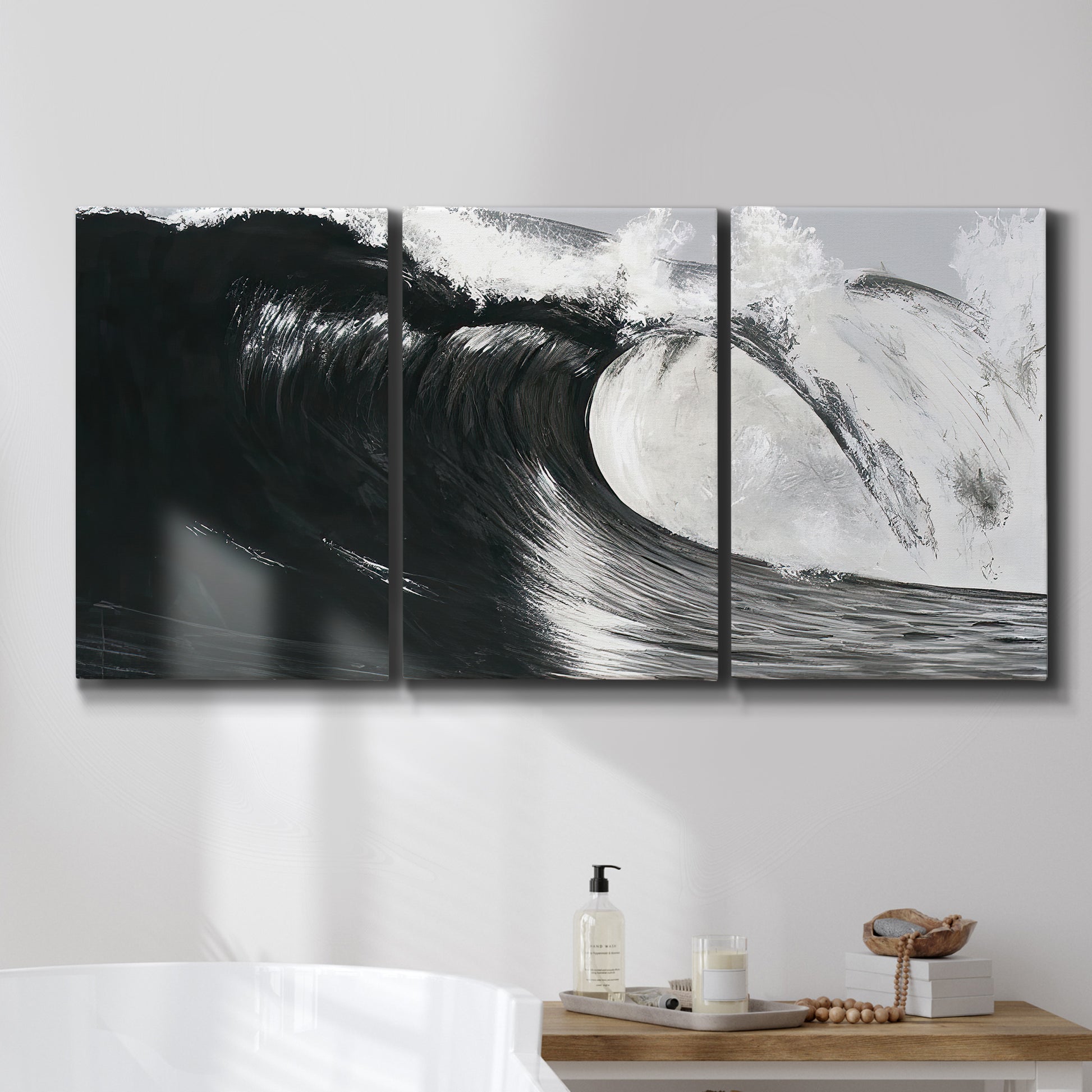 Three-panel canvas wall art featuring black and white crashing ocean waves, displayed in a bathroom above a bathtub.