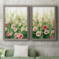 Set of two gray barnwood framed canvas prints depicting a coordinated art pair of a field of pink coral and white flowers rendered as luminous impressionistic floral paintings above a sofa in a modern living room.