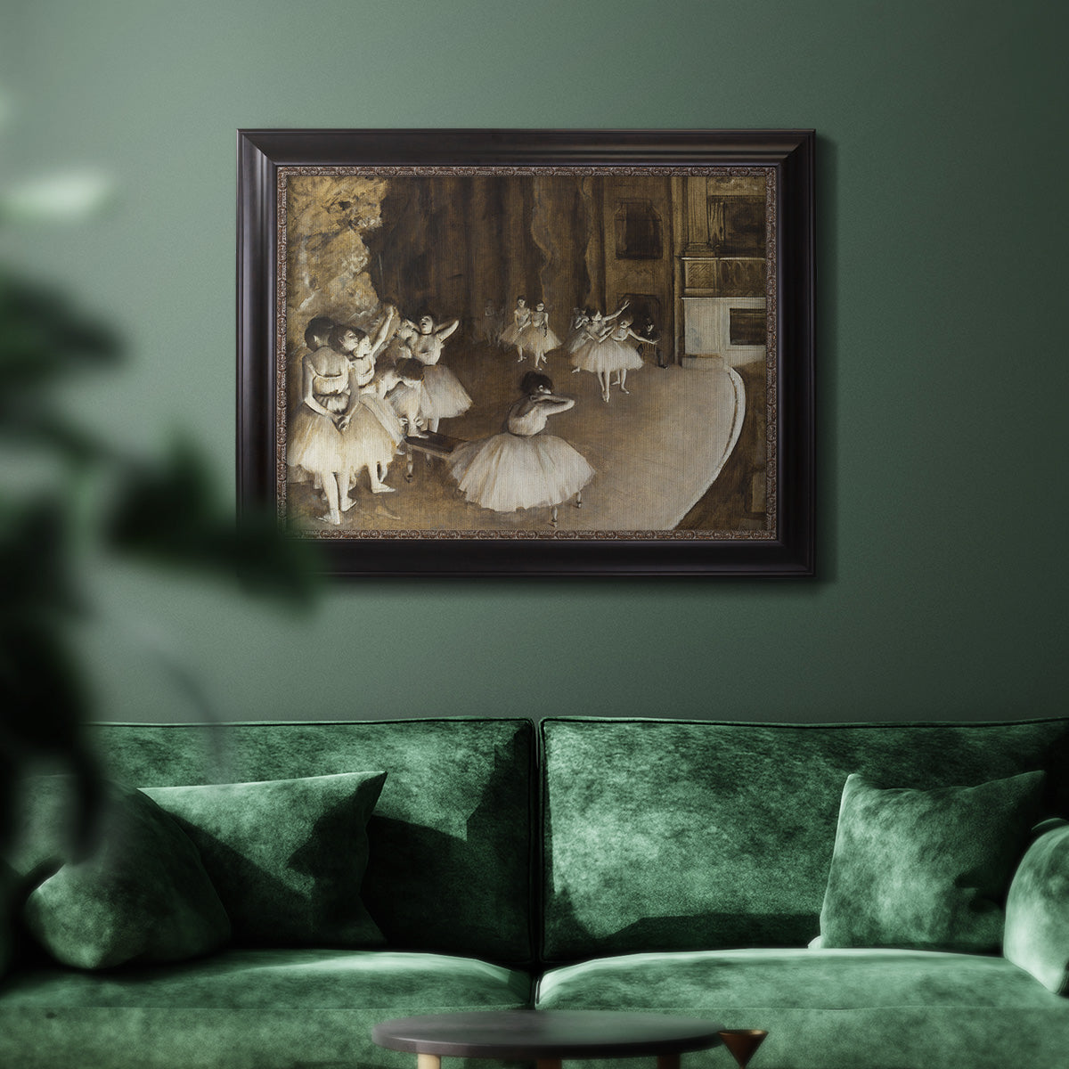 Impressionist ballet rehearsal scene by Edgar Degas in an ornate black frame with gilded inner detail displayed in a dark-toned interior setting.