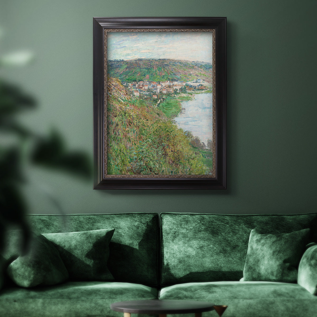 Impressionist landscape view of Vétheuil by Claude Monet in an ornate black frame with gilded inner detail displayed in a dark-toned interior setting.