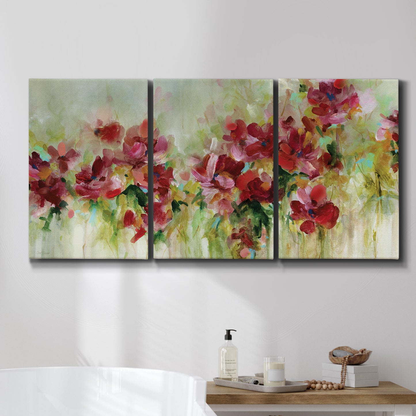 Three-panel canvas wall art featuring colorful floral garden composition, displayed in a bathroom above a bathtub.