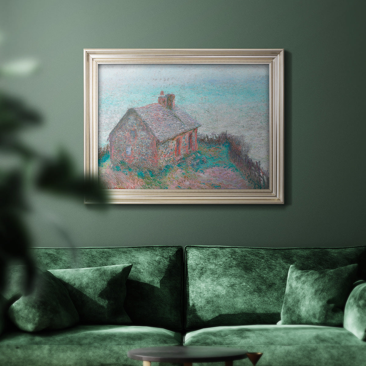 Impressionist coastal building landscape by Claude Monet in an ornate champagne frame displayed in a dark-toned interior setting.