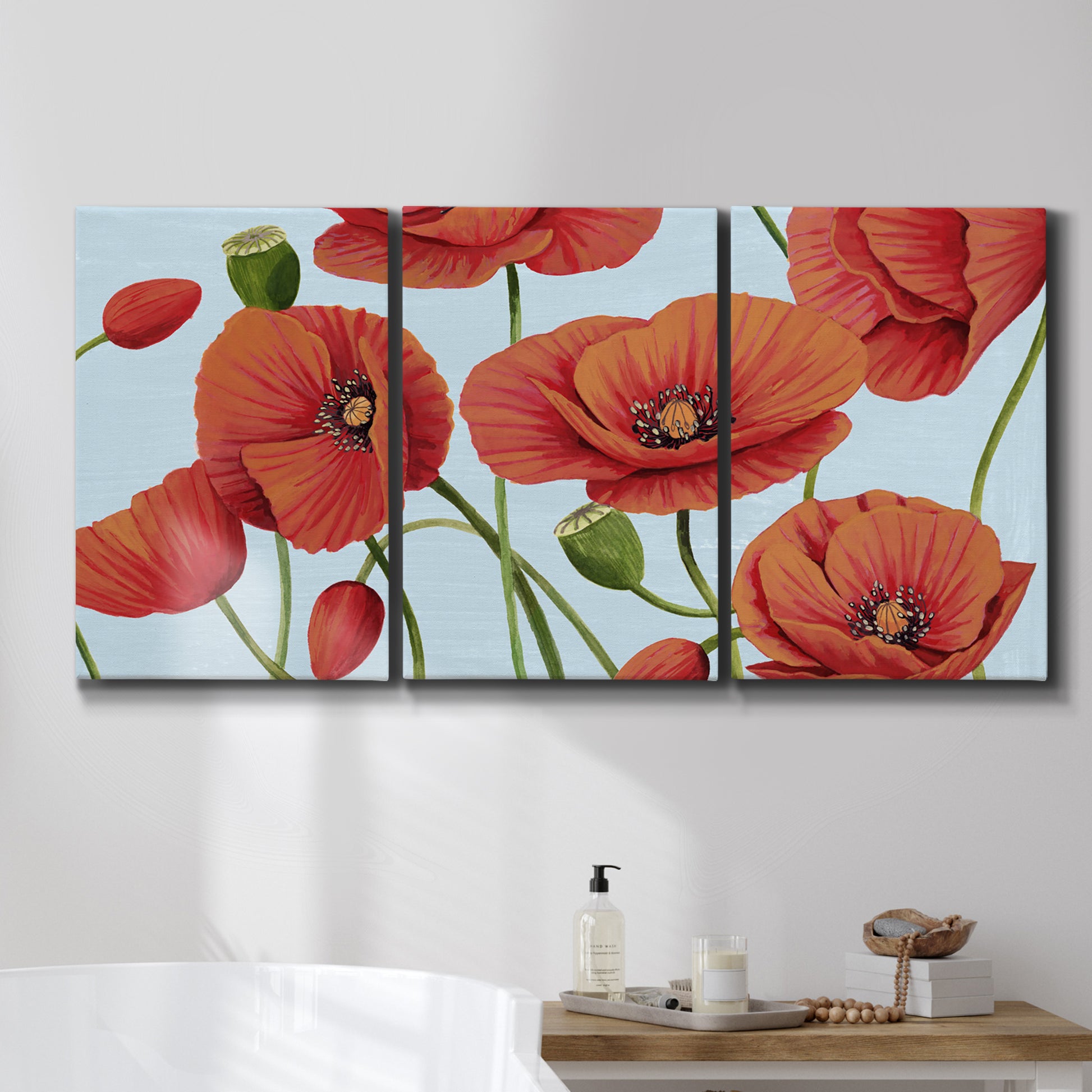 Three-panel canvas wall art featuring red poppies in motion, displayed in a bathroom above a bathtub.