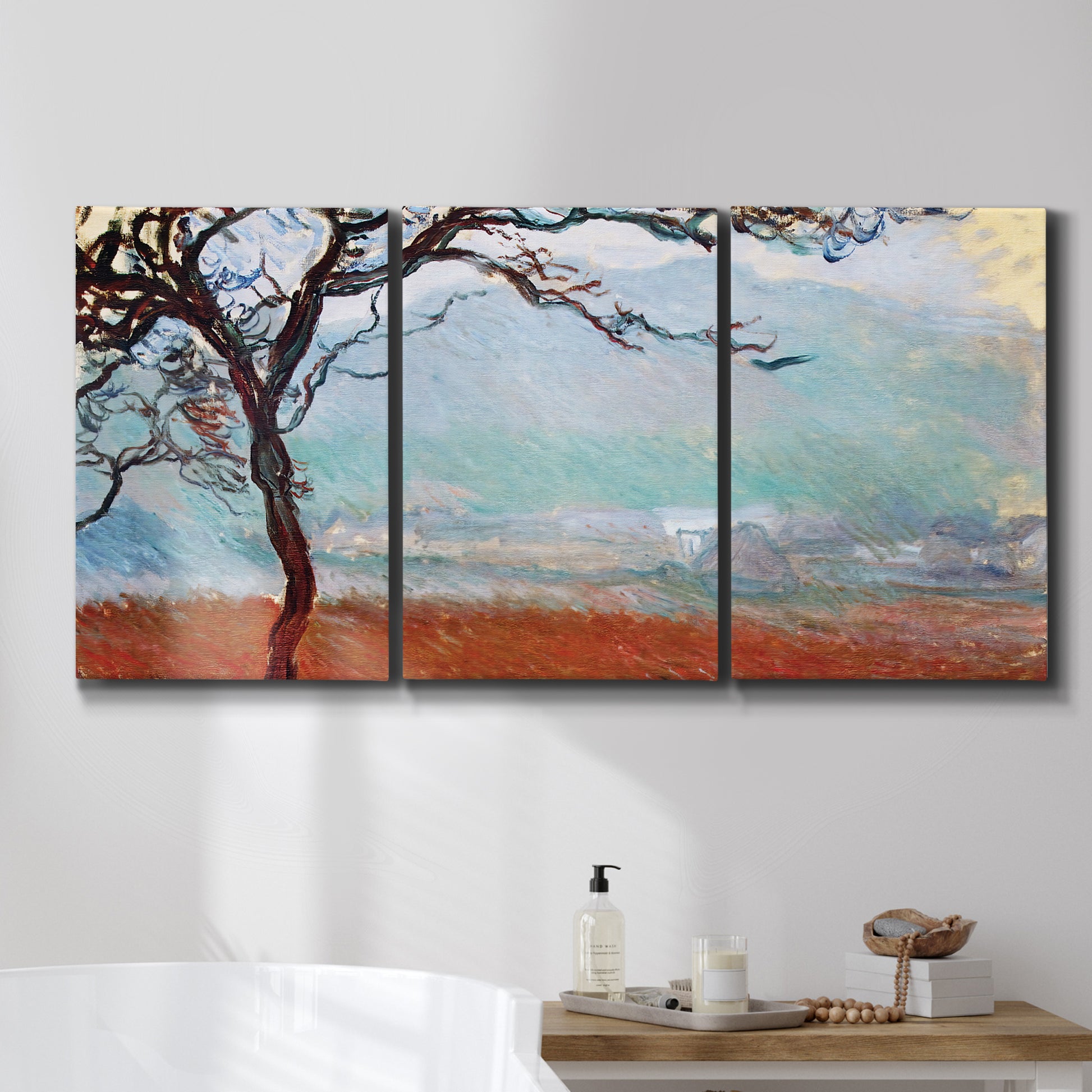 Three-panel canvas wall art featuring coastal trees at evening light, displayed in a bathroom above a bathtub.