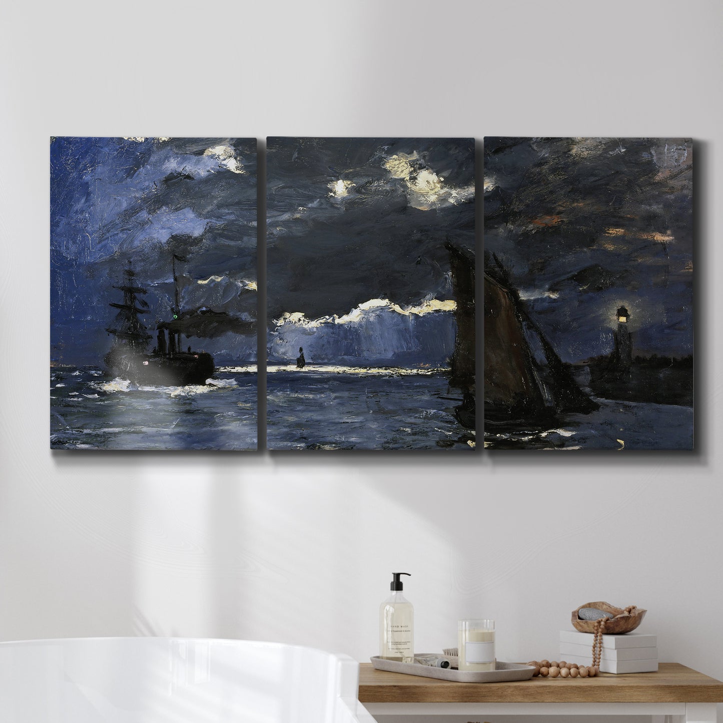 Three-panel canvas wall art featuring dark seascape under night sky, displayed in a bathroom above a bathtub.