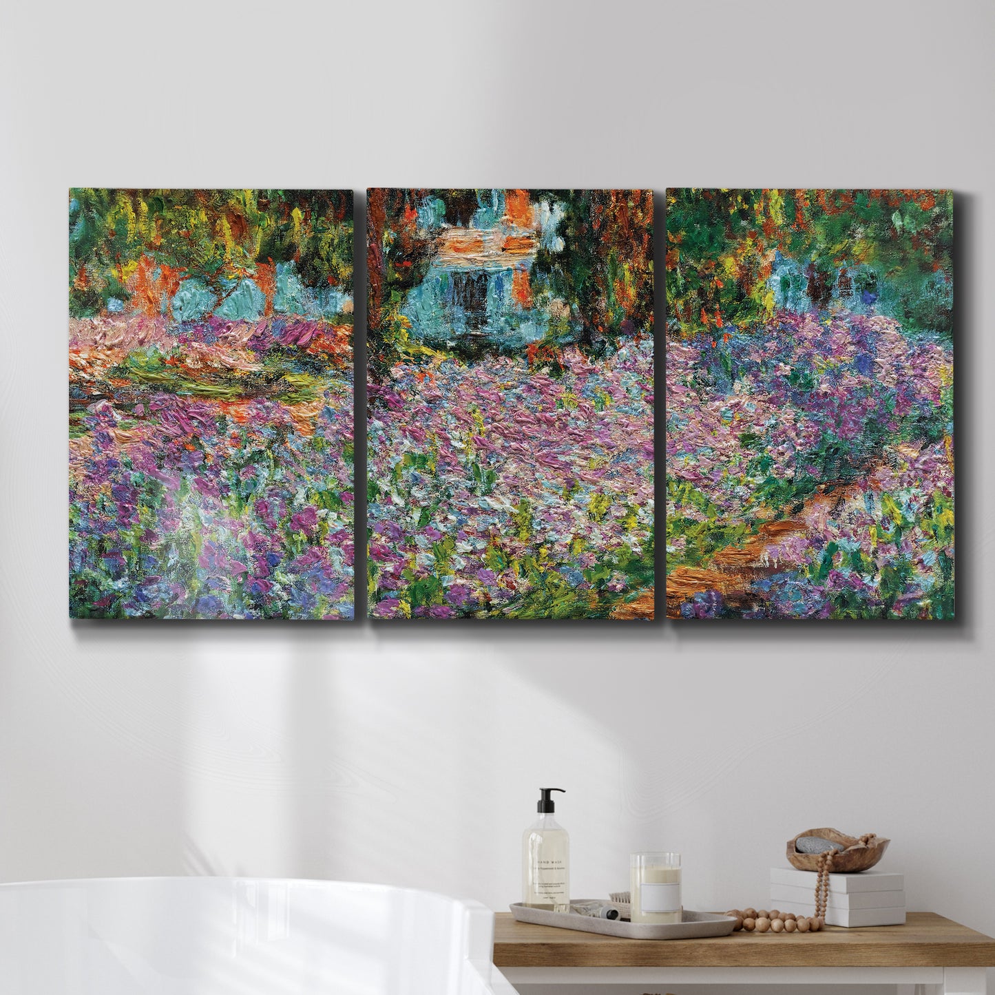 Three-panel canvas wall art featuring blooming irises in garden bed, displayed in a bathroom above a bathtub.