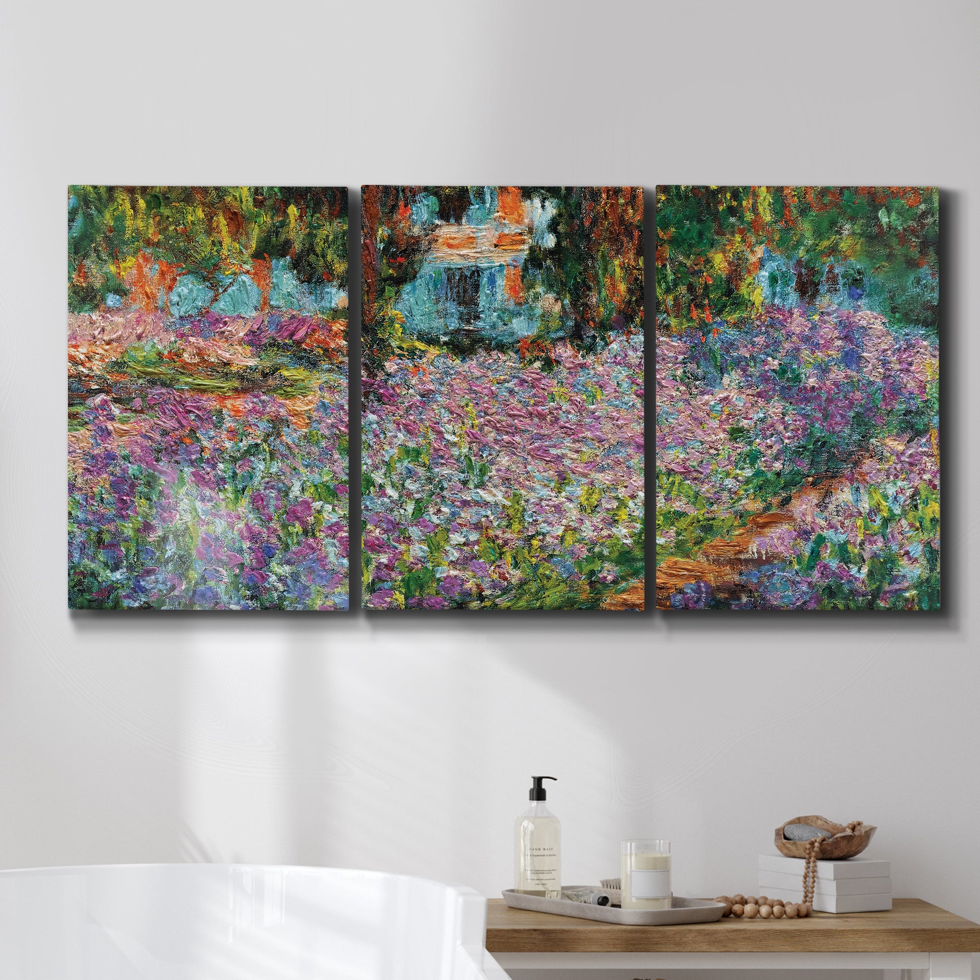 Three-panel canvas wall art featuring blooming irises in garden bed, displayed in a bathroom above a bathtub.