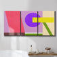 Three-panel canvas wall art featuring bold geometric color abstraction, displayed in a bathroom above a bathtub.