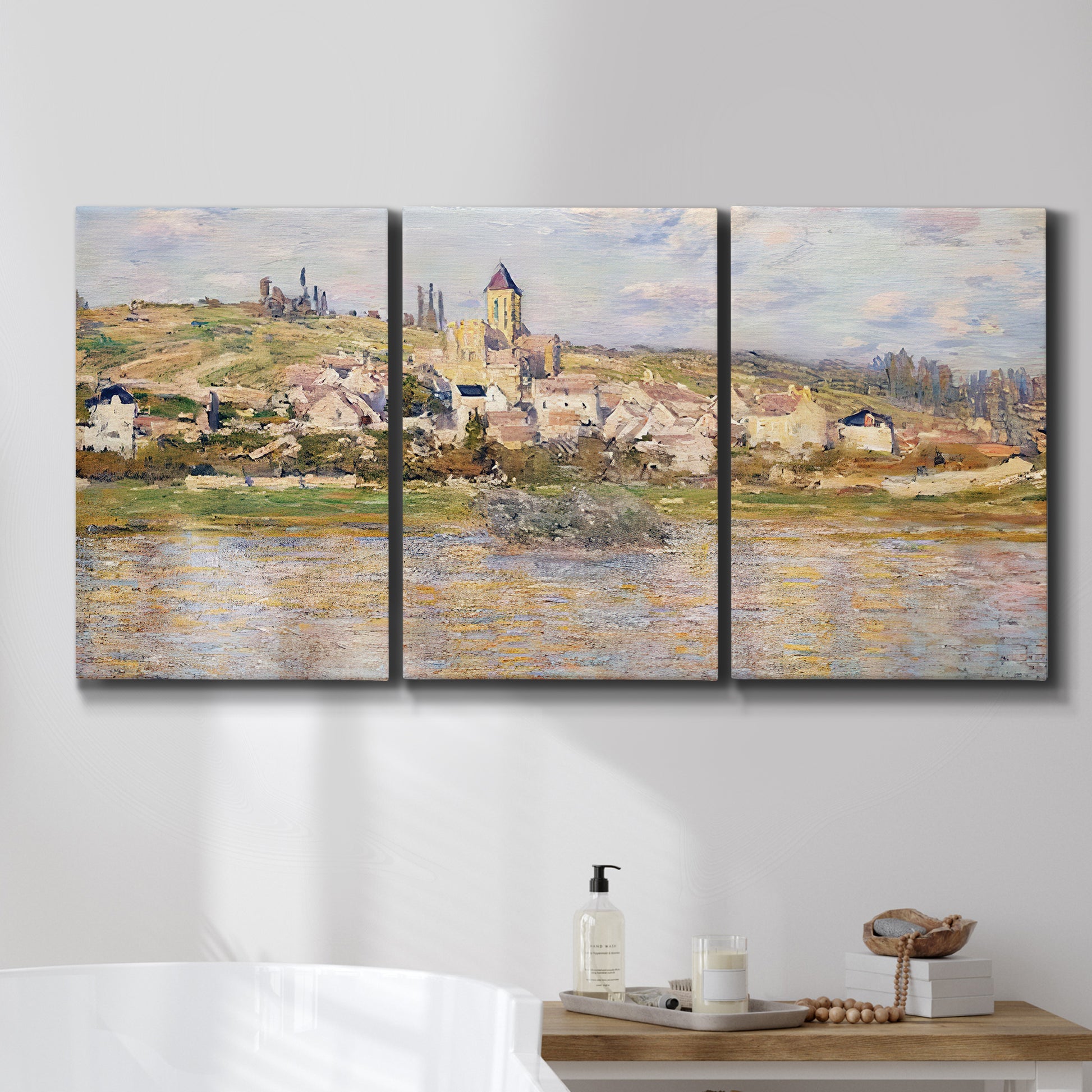 Three-panel canvas wall art featuring village overlooking river valley, displayed in a bathroom above a bathtub.