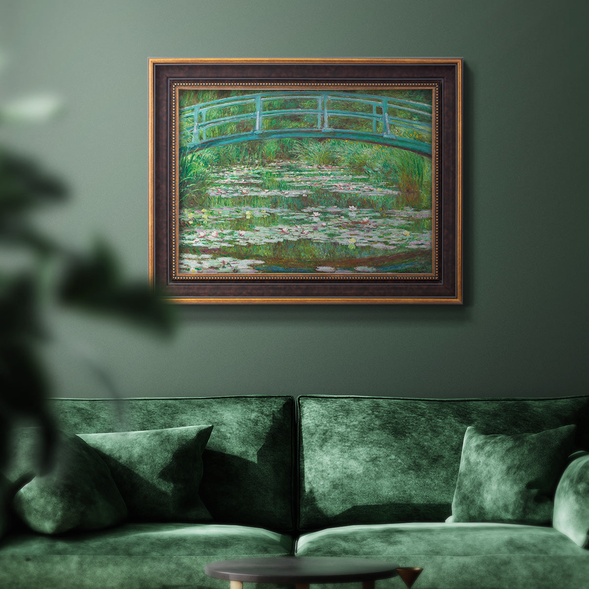 Impressionist garden scene with Japanese bridge and water lilies by Claude Monet in an ornate bronzed mahogany wood frame displayed in a dark-toned interior setting.