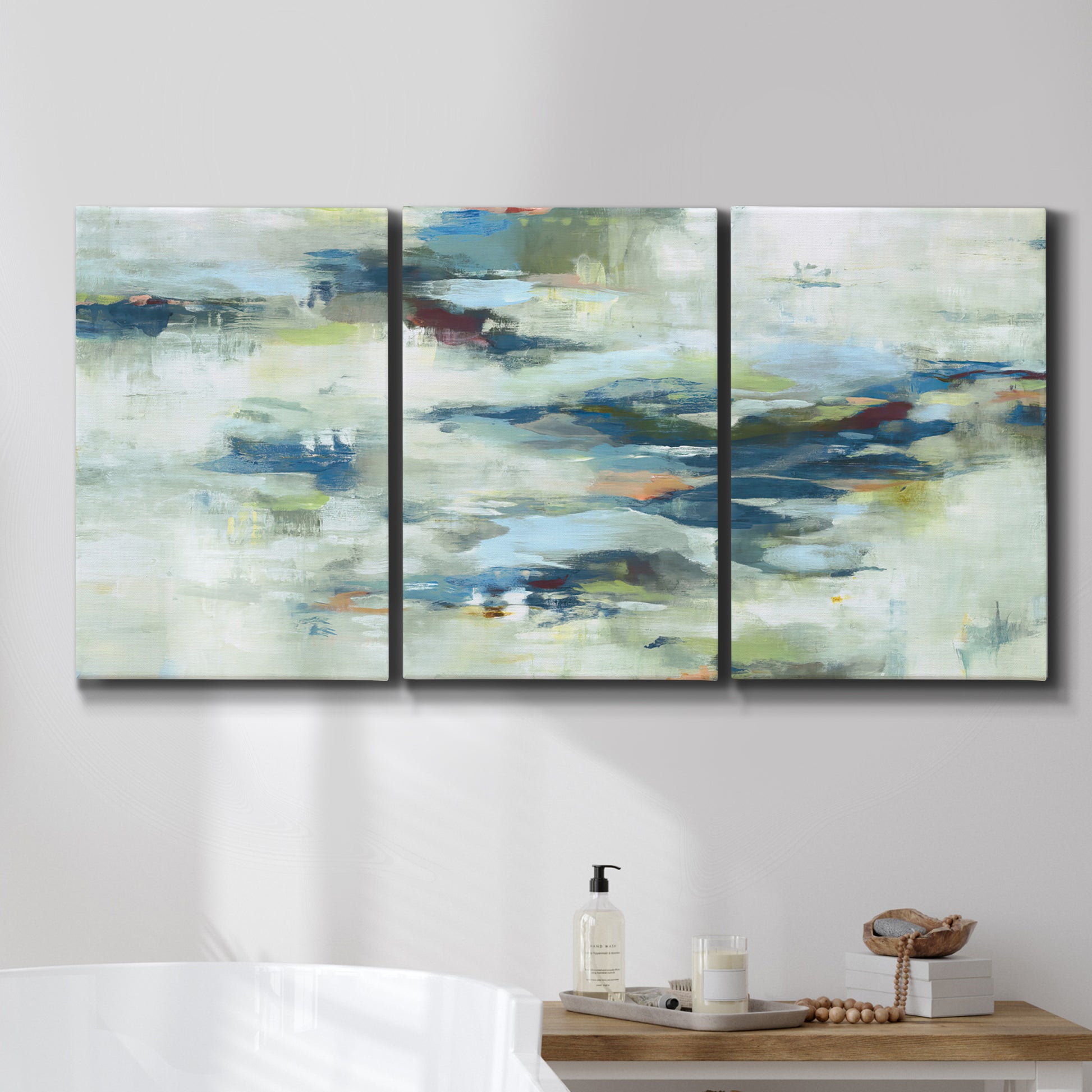 Three-panel canvas wall art featuring dreamlike abstract drifting motion, displayed in a bathroom above a bathtub.