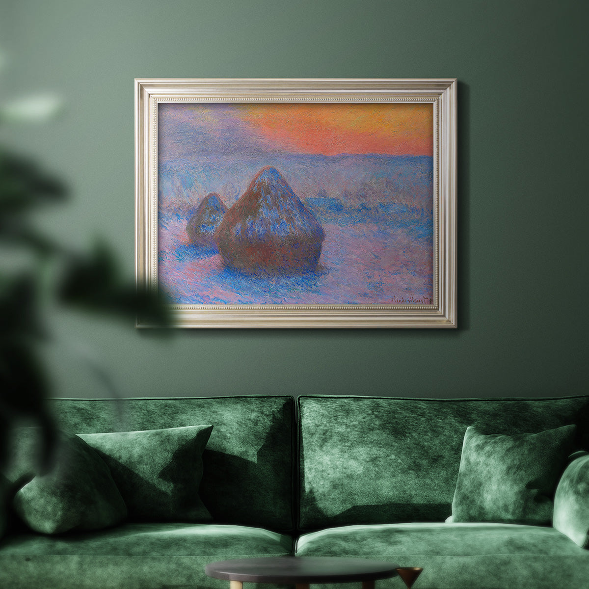 Impressionist haystack scene at sunset by Claude Monet in an ornate champagne frame displayed in a dark-toned interior setting.
