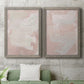 Set of two gray barnwood framed canvas prints depicting a coordinated art pair of soft blush and white painterly fields rendered as minimalist color-field abstracts above a sofa in a modern living room.