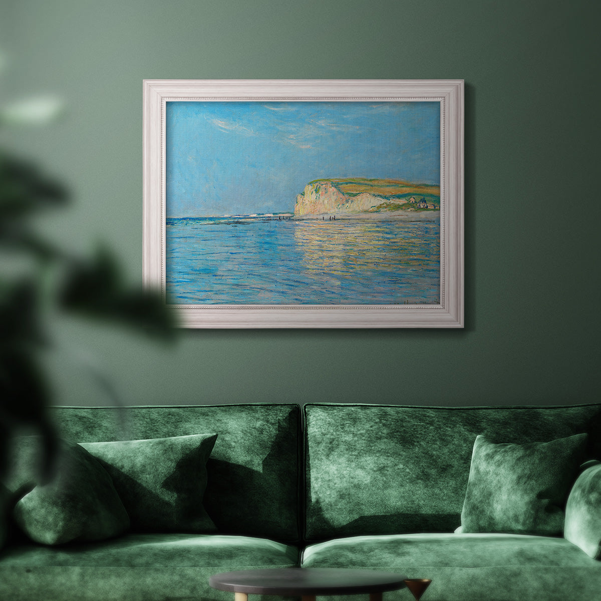 Impressionist coastal low-tide seascape at Pourville by Claude Monet in an ornate weathered white frame displayed in a dark-toned interior setting.