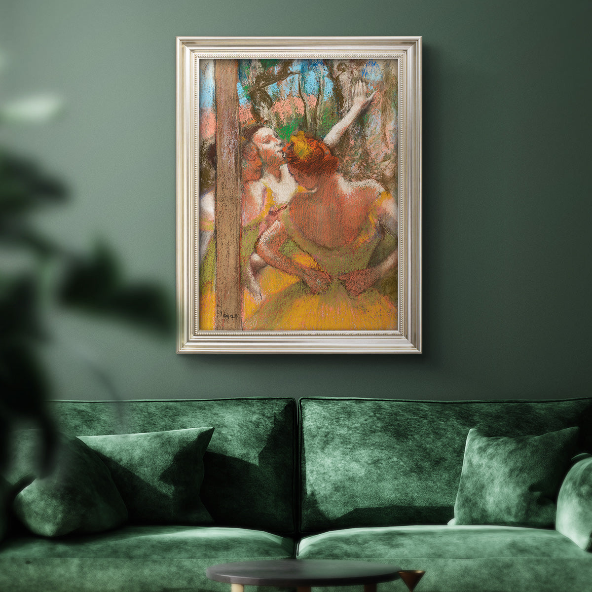 Impressionist ballet dancer composition by Edgar Degas in an ornate champagne frame displayed in a dark-toned interior setting.