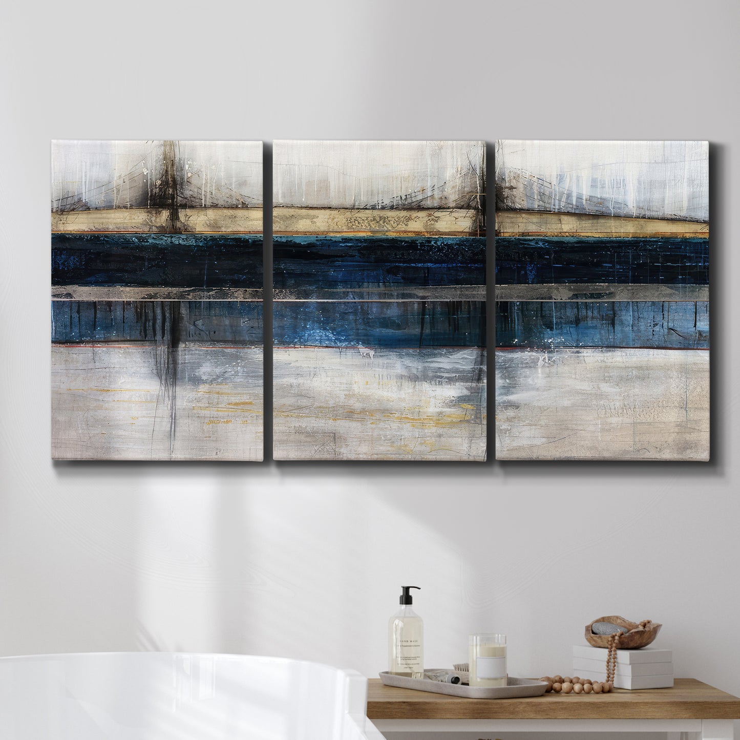 Three-panel canvas wall art featuring abstract blue urban composition, displayed in a bathroom above a bathtub.