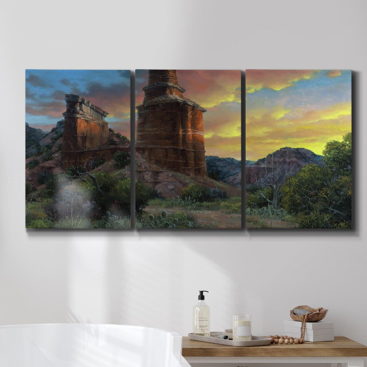 Three-panel canvas wall art featuring dramatic canyon landscape at dusk, displayed in a bathroom above a bathtub.