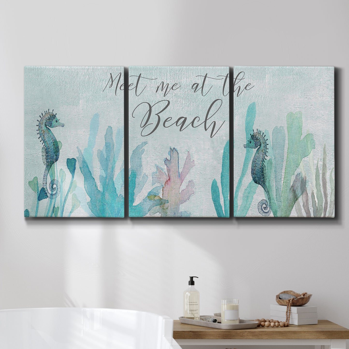 Three-panel canvas wall art featuring coastal typography with seahorses, displayed in a bathroom above a bathtub.