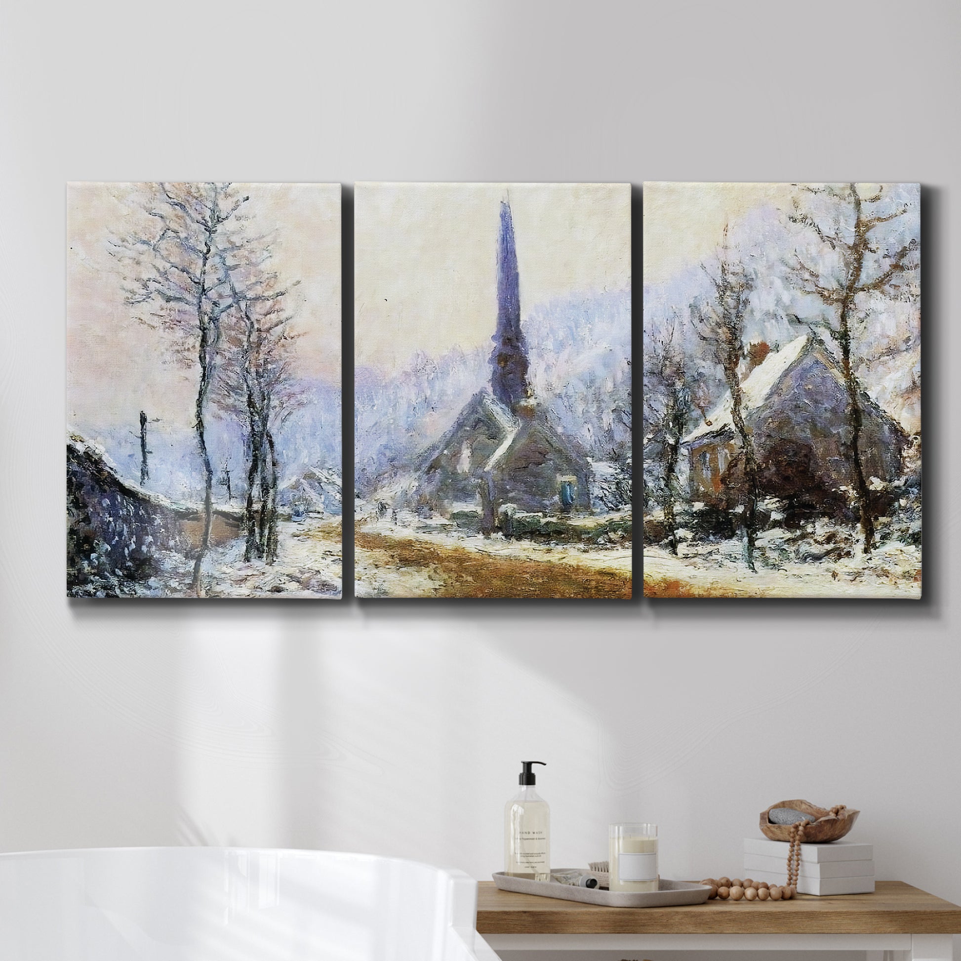 Three-panel canvas wall art featuring snow covered road leading to village, displayed in a bathroom above a bathtub.