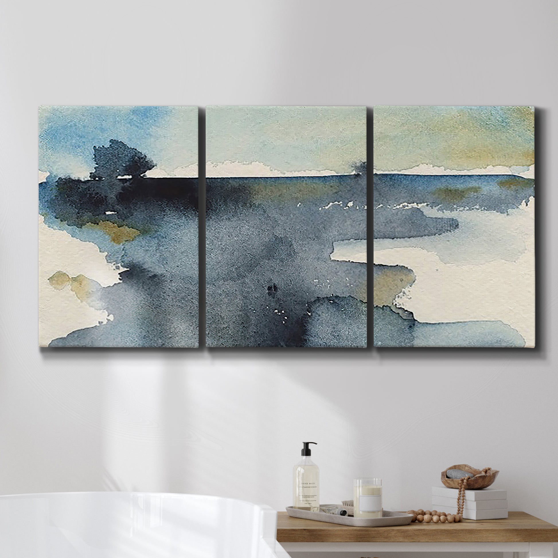 Three-panel canvas wall art featuring abstract watercolor with upward motion, displayed in a bathroom above a bathtub.
