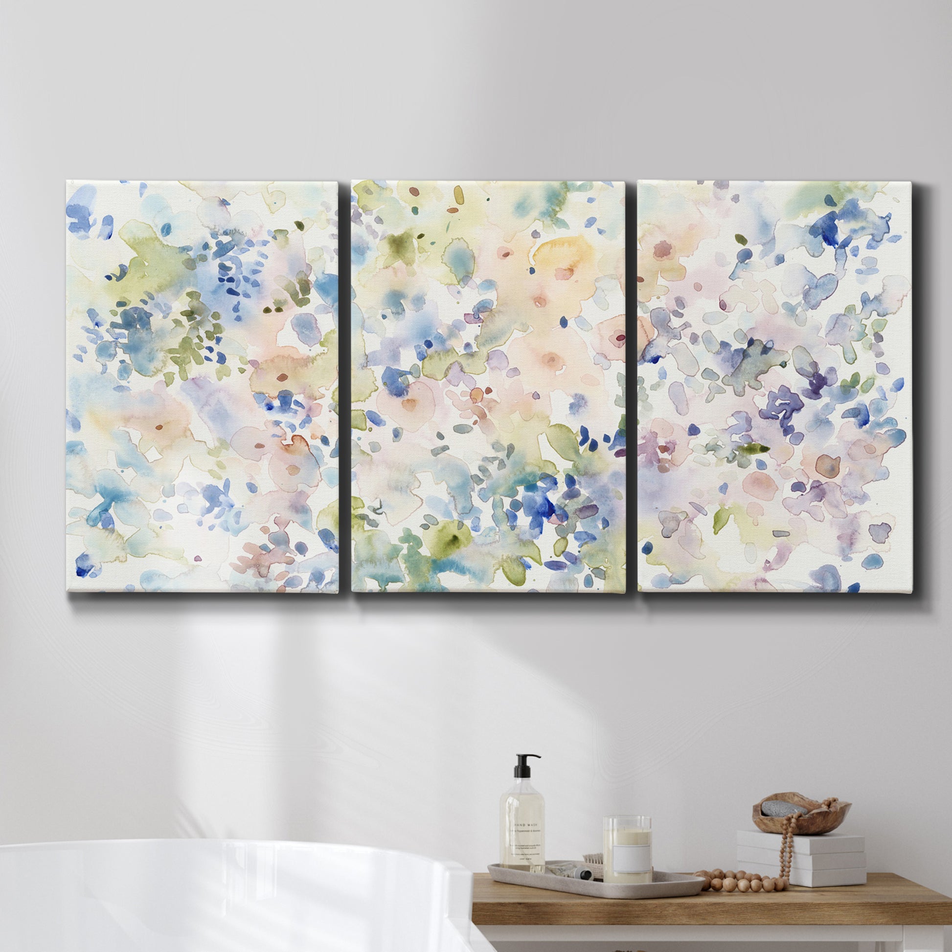 Three-panel canvas wall art featuring flowing abstract watercolor, displayed in a bathroom above a bathtub.