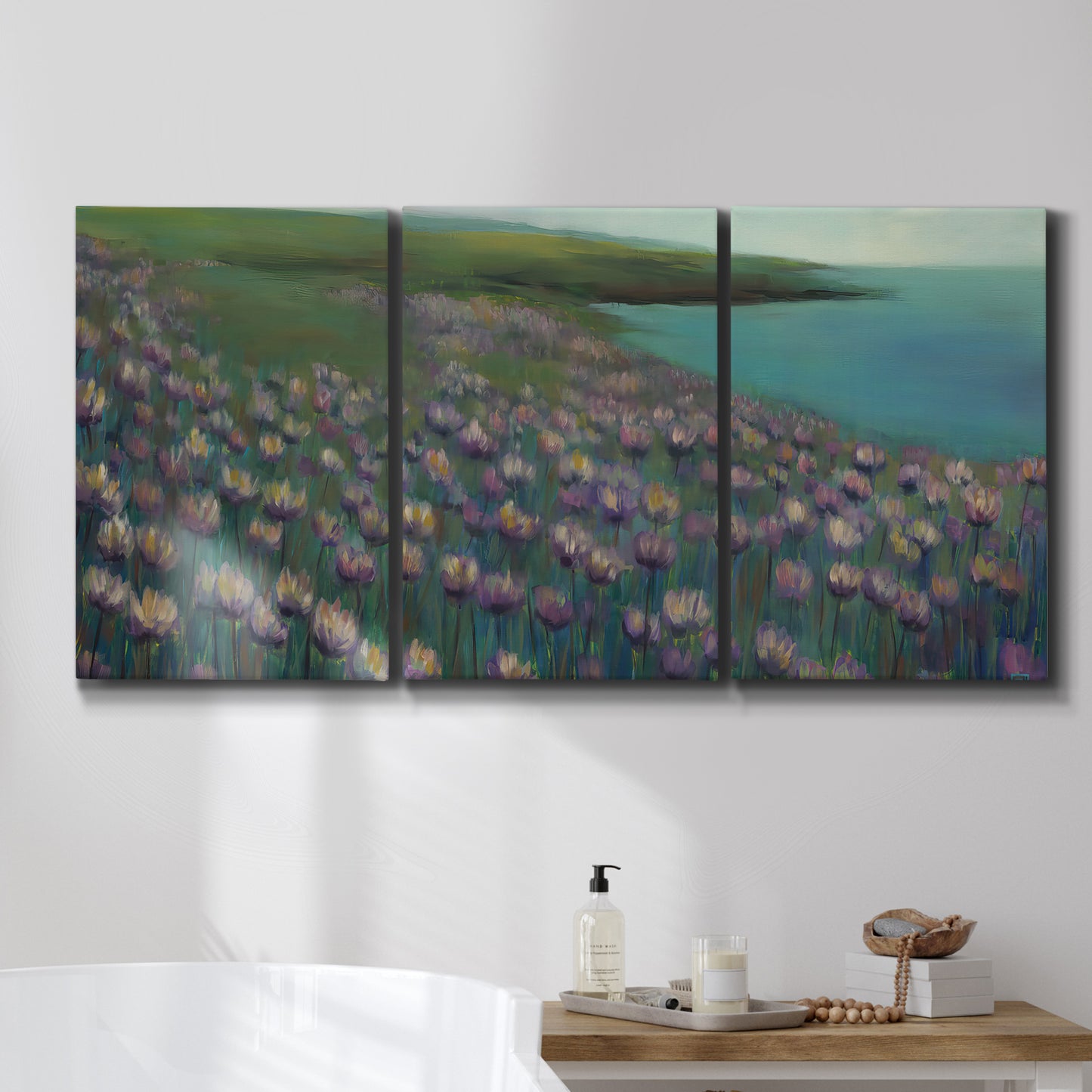 Three-panel canvas wall art featuring calm coastal landscape sanctuary, displayed in a bathroom above a bathtub.