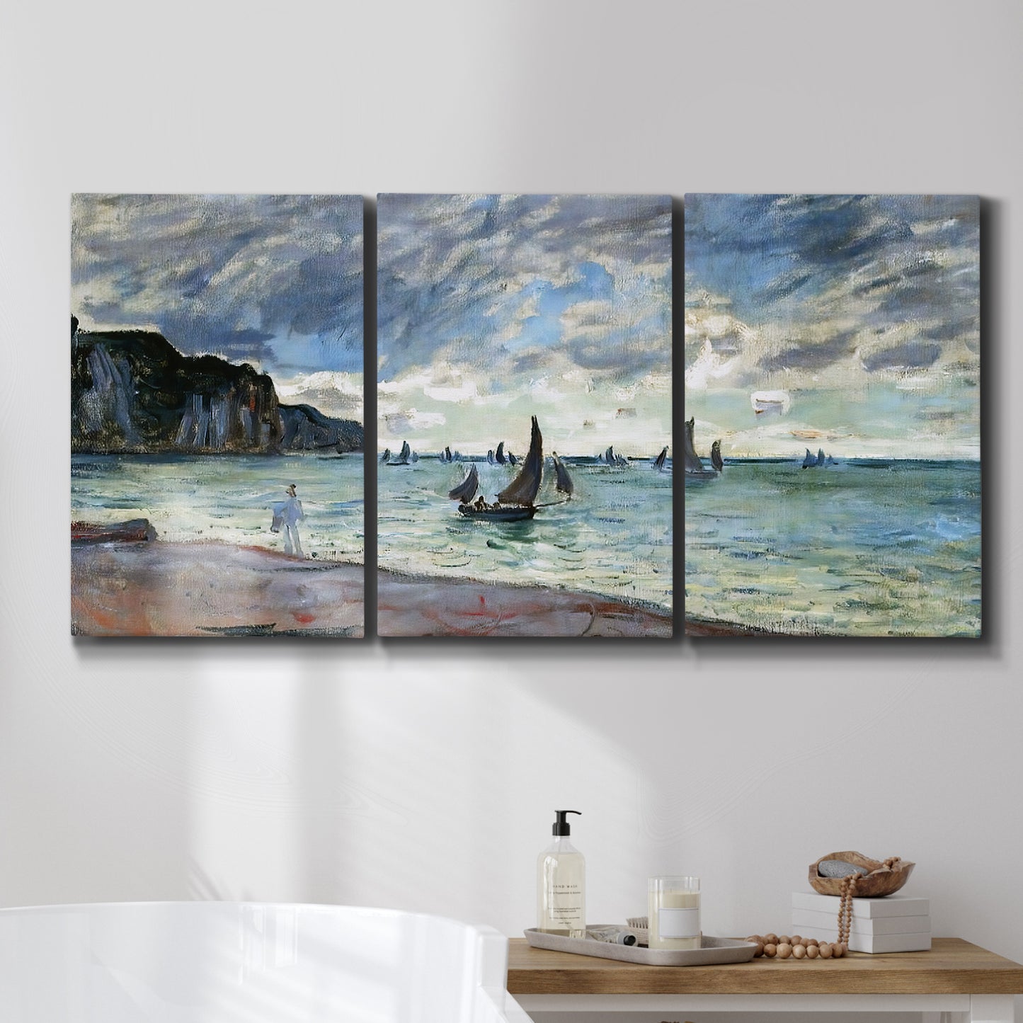 Three-panel canvas wall art featuring figures walking along sandy shoreline, displayed in a bathroom above a bathtub.